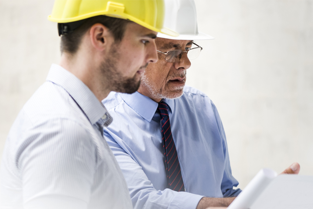 Engineers reviewing plans on site at construction project