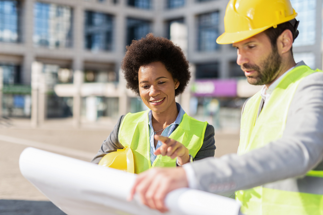 Building contractors analyzing blueprint at construction site